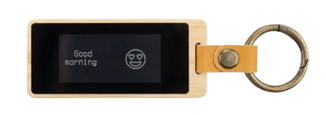 Front of a KEEP bamboo keychain — screen reading 'Good morning' next to a heart-eyes emoji.