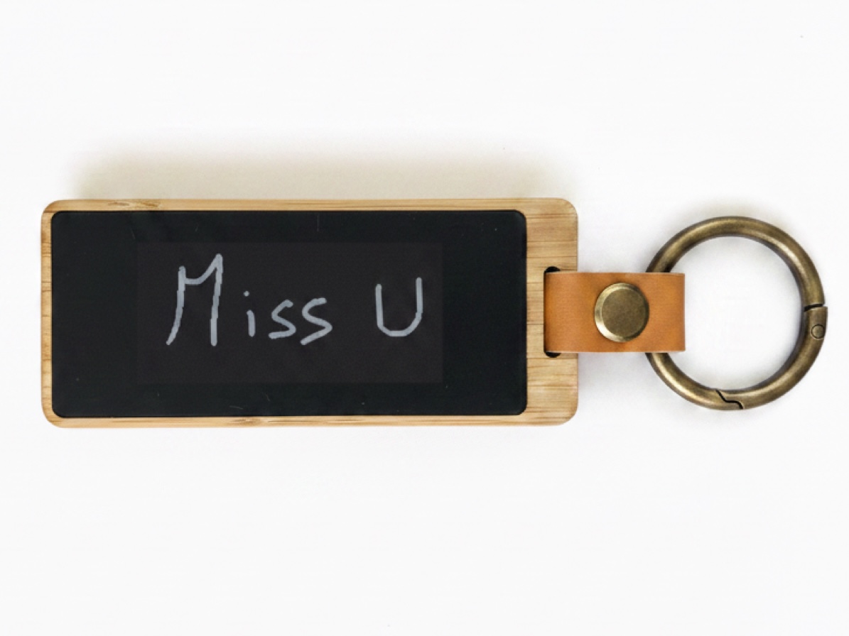 Un porte-clés KEEP, écran e-ink avec un « Tu me manques » écrit à la main.