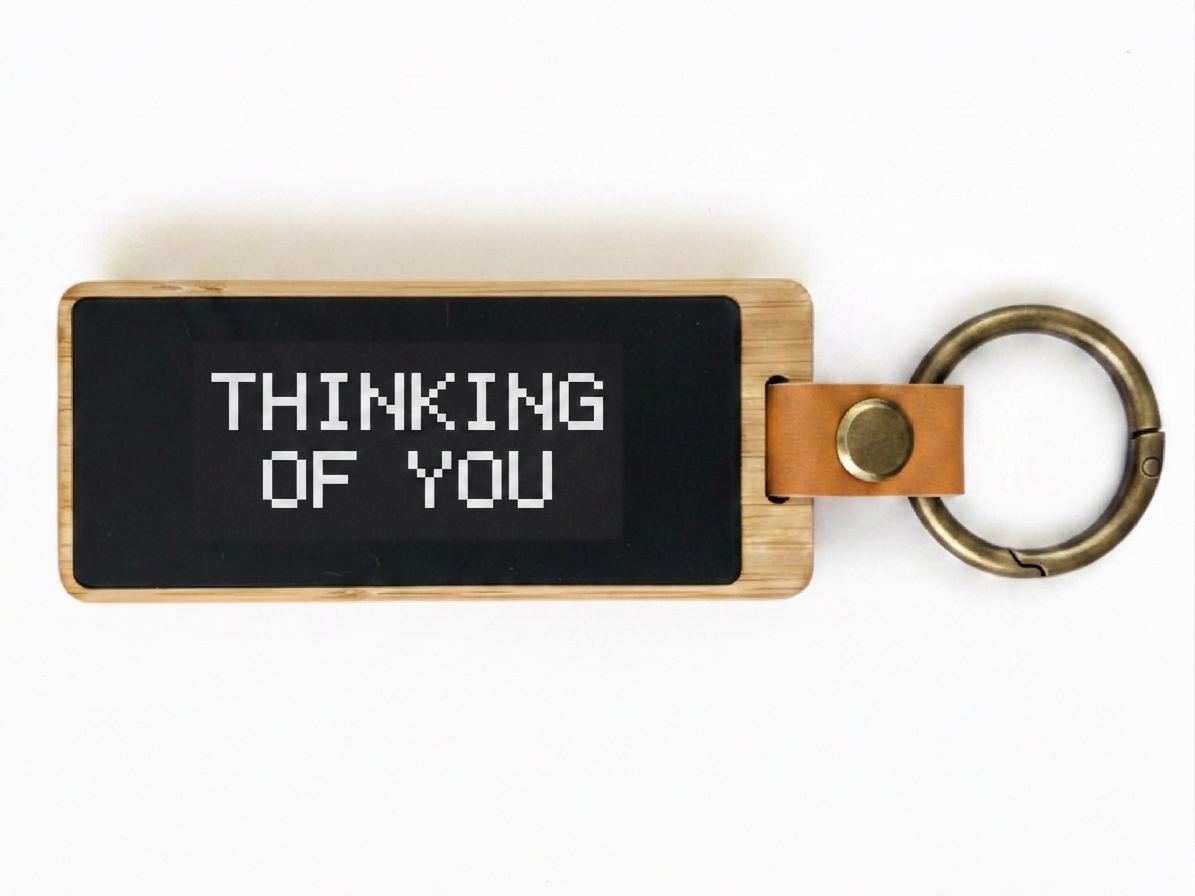 Un porte-clés KEEP, écran e-ink affichant « Je pense à toi ».
